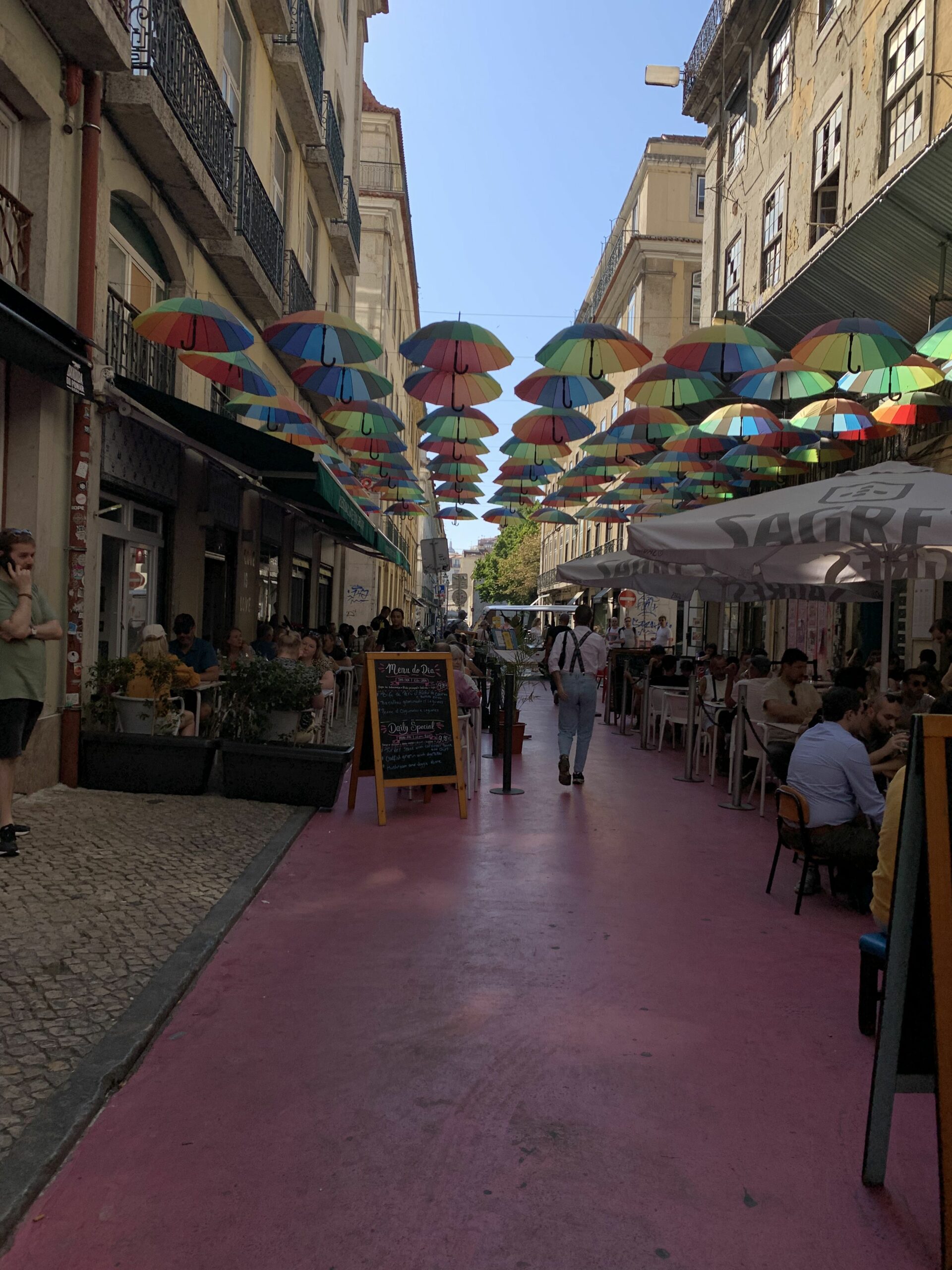 pinke Straße mit Regenschirmen und Bars in Lissabon 